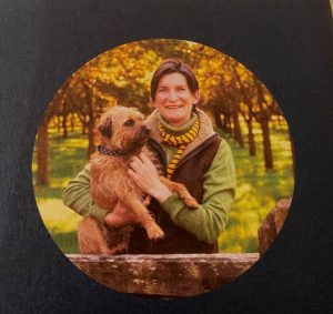 Tamsin Westhorpe with terrier at an orchard gate